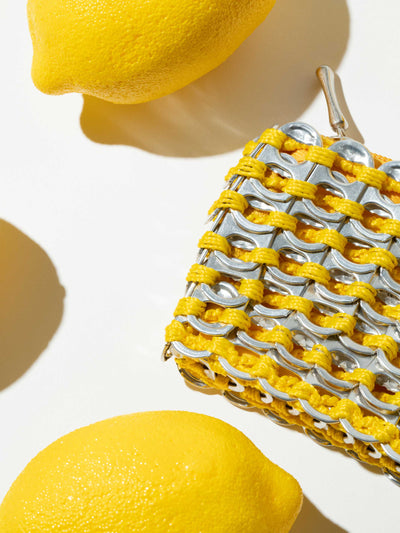alt="yellow lemons and yellow purse sustainable - soda pop tab purse escama studio"
