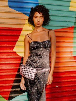 woman in black dress wearing a fanny pack made of soda tabs