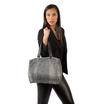 alt="black tote worn by woman in black jacket and pants, Kate bag by Escama Studio"