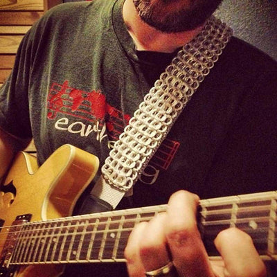 alt="cool silver guitar strap that looks like metal with Gibson semi hollow body guitar player"