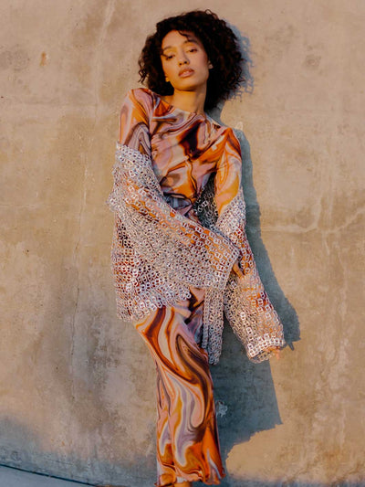 woman in orange swirl dress and silver metallic jacket made of pop tabs - escama studio